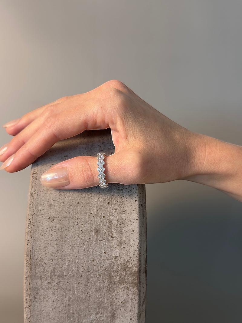 PAIGEAVERI white gold hinged diamond eternity ring with brilliant-cut diamonds, shown on a thumb.